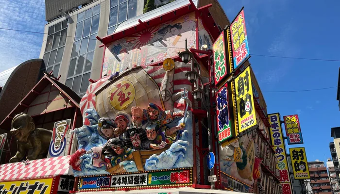 串かつ店や射的の大きな看板が並ぶ、にぎやかな新世界の街並み